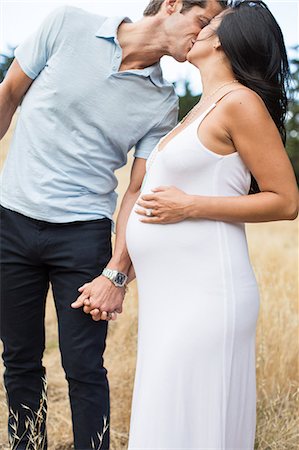 simsearch:614-07031597,k - Pregnant woman and mature man, holding hands, kissing, outdoors Stock Photo - Premium Royalty-Free, Code: 614-08946157