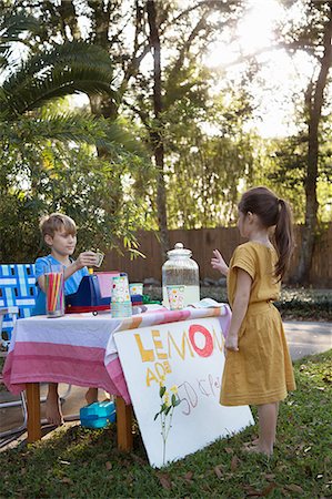 Girl buying lemonade from lemonade stand in garden Stock Photo - Premium Royalty-Free, Code: 614-08946615