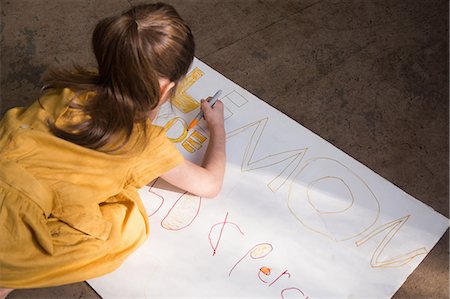 sell lemonade - Girl crouching to colour in lemonade stand sign Stock Photo - Premium Royalty-Free, Code: 614-08946612