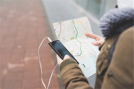 simsearch:614-08946703,k - Over shoulder view of female backpacker with smartphone looking at map on city sidewalk Photographie de stock - Premium Libres de Droits, Code: 614-08946718