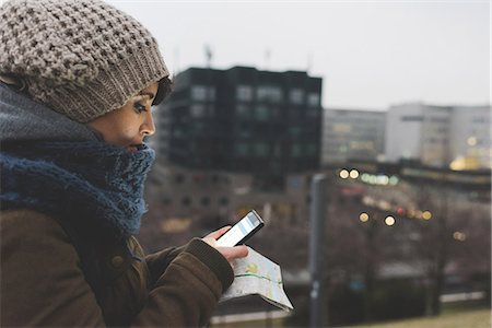simsearch:614-08946703,k - Woman in knit hat looking at smartphone in city at dusk Photographie de stock - Premium Libres de Droits, Code: 614-08946736