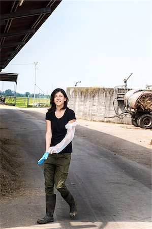 portrait farmer not backlit not flare - Female organic farmer putting on protective glove at dairy farm Stock Photo - Premium Royalty-Free, Code: 614-08946793