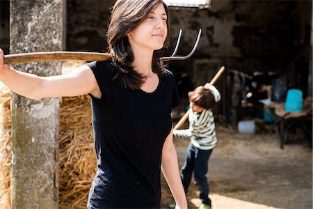 Female organic farmer with pitch fork over her shoulder on dairy farm Photographie de stock - Premium Libres de Droits, Code: 614-08946802