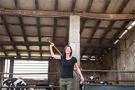 farmers with dairy cows - Female organic farmer with pitch fork over her shoulder on dairy farm Stock Photo - Premium Royalty-Free, Code: 614-08946803