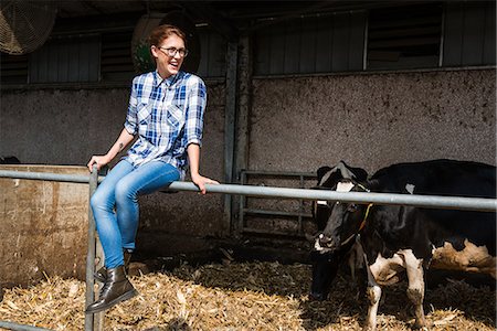 farmers with dairy cows - Female farmer sitting on fence at organic dairy farm Stock Photo - Premium Royalty-Free, Code: 614-08946813