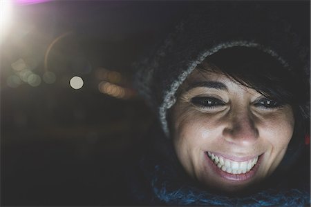 simsearch:614-08946703,k - Illuminated close up of happy woman wearing knit hat at night Photographie de stock - Premium Libres de Droits, Code: 614-08946825