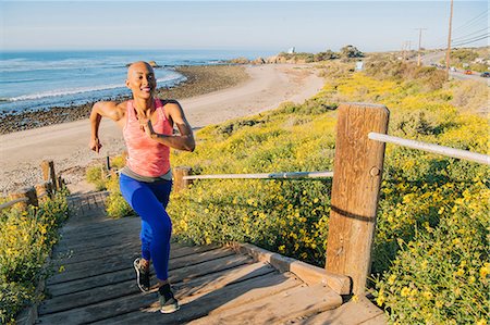 stepping up - Young woman exercising, running up steps near beach, elevated view Stock Photo - Premium Royalty-Free, Code: 614-08984093