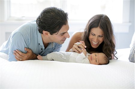 simsearch:700-07240913,k - Mother and father leaning on bed, looking at newborn baby boy Photographie de stock - Premium Libres de Droits, Code: 614-08984106