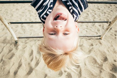 Portrait of boy hanging upside down over sand, smiling, Santa Barbara, California, USA Stock Photo - Premium Royalty-Free, Code: 614-08984121