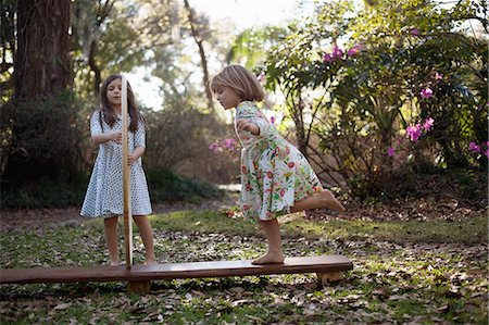 simsearch:614-08878321,k - Girl holding plastic hoops with sister running through Fotografie stock - Premium Royalty-Free, Codice: 614-08984143