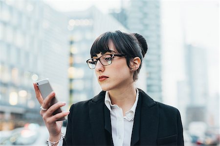 Businesswoman using mobile, Milan, Italy Stock Photo - Premium Royalty-Free, Code: 614-08984217