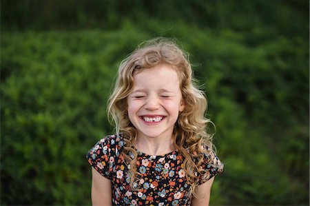 Portrait of girl with wavy blond hair and missing tooth in field Fotografie stock - Premium Royalty-Free, Codice: 614-08984255