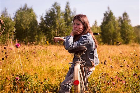 simsearch:614-08202342,k - Teenage girl sitting on bicycle in long grassy field Foto de stock - Sin royalties Premium, Código: 614-08984250