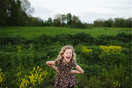 Portrait of girl with wavy blond hair laughing in field Fotografie stock - Premium Royalty-Free, Codice: 614-08984253