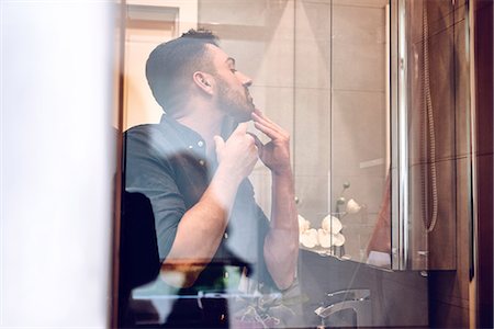 View through glass of man shaving Stock Photo - Premium Royalty-Free, Code: 614-08989887