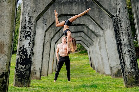 simsearch:614-09127241,k - Young woman balancing on top of man hands, practicing yoga below concrete bridge Foto de stock - Sin royalties Premium, Código: 614-08982685