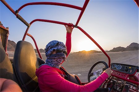 simsearch:614-06974581,k - Young woman with head wrapped in scarf driving beach buggy in desert, Hurghada, Al Bahr al Ahmar, Egypt Foto de stock - Sin royalties Premium, Código: 614-08982754