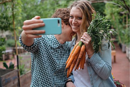 people in a garden - Couple in garden with carrots, taking selfie Stock Photo - Premium Royalty-Free, Code: 614-08982884