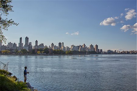 Teenage boy fishing from riverbank, New York, USA Stock Photo - Premium Royalty-Free, Code: 614-08982894