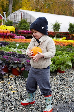 fall imagery rainboots - Boy carrying pumpkin in garden centre Stock Photo - Premium Royalty-Free, Code: 614-08982902