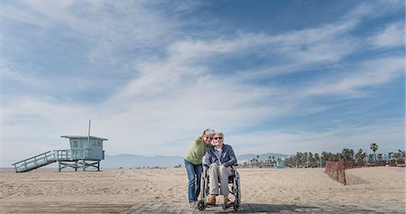 panoramique - Senior man in wheelchair with wife pointing from beach, Santa Monica, California, USA Photographie de stock - Premium Libres de Droits, Code: 614-08982912