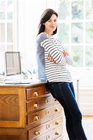 simsearch:614-08884375,k - Portrait of female designer leaning against drawers in creative studio Foto de stock - Royalty Free Premium, Número: 614-08982964