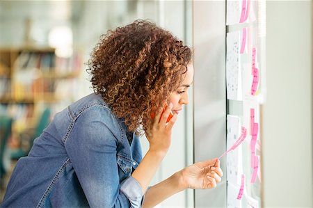 simsearch:614-08983076,k - Female digital designer making phone call and looking at adhesive notes on office wall Stock Photo - Premium Royalty-Free, Code: 614-08983050