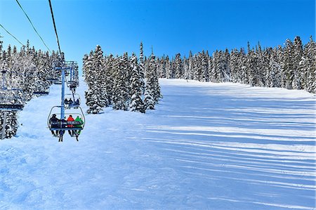Rear view of skiers on ski lift moving up snow covered landscape, Aspen, Colorado, USA Photographie de stock - Premium Libres de Droits, Code: 614-08983395