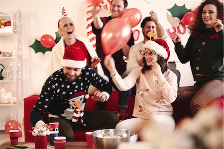 Young women and men having fun laughing at christmas party Stock Photo - Premium Royalty-Free, Code: 614-08983439