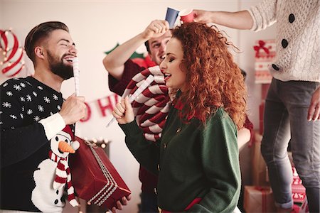 Young man and woman singing with pretend microphones at christmas party Stock Photo - Premium Royalty-Free, Code: 614-08983444