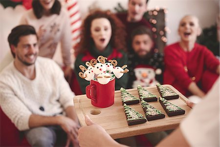 simsearch:614-02258138,k - Over shoulder view of young woman serving friends with christmas biscuits at christmas party Stock Photo - Premium Royalty-Free, Code: 614-08983447