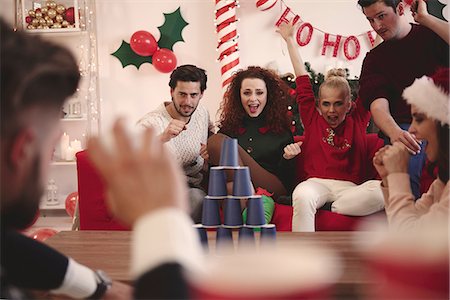 simsearch:614-08983460,k - Young adult friends throwing ball at paper cup pyramid at christmas party Foto de stock - Royalty Free Premium, Número: 614-08983449