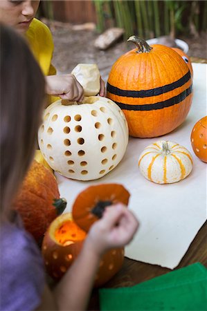 simsearch:614-09057086,k - Over shoulder view of girl and brother preparing pumpkins on garden table Photographie de stock - Premium Libres de Droits, Code: 614-08983555