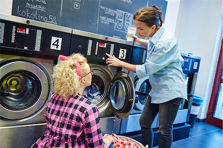 simsearch:614-08983600,k - Laundrette business owner showing woman washing machine control panel Foto de stock - Sin royalties Premium, Código: 614-08983626