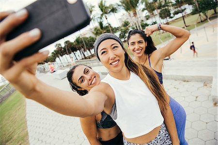 simsearch:614-08535703,k - Three female friends, wearing sports clothing, taking selfie using smartphone, South Point Park, Miami Beach, Florida, USA Stock Photo - Premium Royalty-Free, Code: 614-08983849