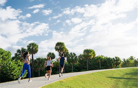 Three friends, running together outdoors, rear view, South Point Park, Miami Beach, Florida, USA Stock Photo - Premium Royalty-Free, Code: 614-08983859