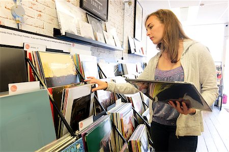 simsearch:649-09269419,k - Young woman looking at stacked vinyl records in record store Stock Photo - Premium Royalty-Free, Code: 614-08990140