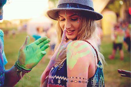 simsearch:614-08685103,k - Young woman with green handprint on shoulder and boyfriend chalked hand at festival Stock Photo - Premium Royalty-Free, Code: 614-08990445