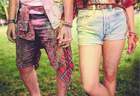 Waist down view of young couple covered in coloured chalk powder at festival Fotografie stock - Premium Royalty-Free, Codice: 614-08990449