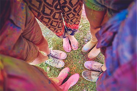 Overhead view of young adults in circle covered in coloured chalk powder at festival Fotografie stock - Premium Royalty-Free, Codice: 614-08990465