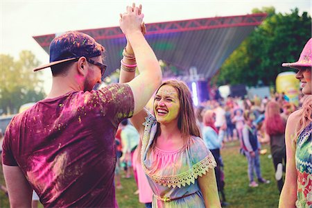 Young adults covered in coloured chalk powder high fiving at festival Fotografie stock - Premium Royalty-Free, Codice: 614-08990460
