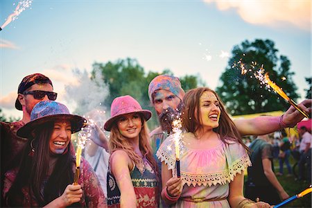 Young adults covered in coloured chalk powder dancing with sparklers at festival Fotografie stock - Premium Royalty-Free, Codice: 614-08990473