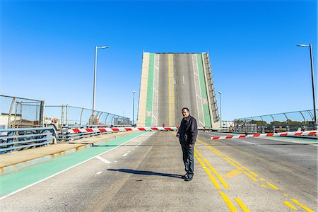 security checkpoint - Portrait of worker in front of barrier and drawbridge at biofuel plant Stock Photo - Premium Royalty-Free, Code: 614-08990510