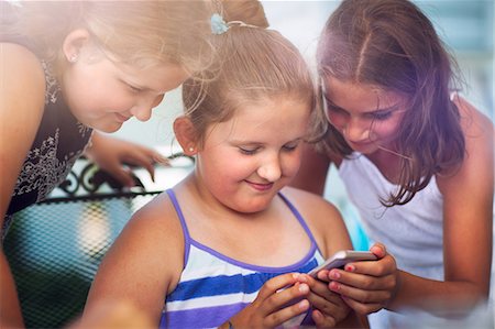 simsearch:6102-08683171,k - Siblings enjoying game on smartphone Photographie de stock - Premium Libres de Droits, Code: 614-08990683
