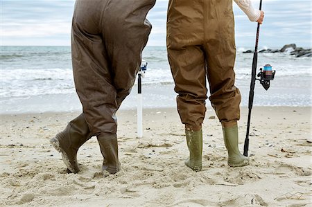 simsearch:614-08990745,k - Waist down rear view of young couple in sea fishing waders on beach Photographie de stock - Premium Libres de Droits, Code: 614-08990762