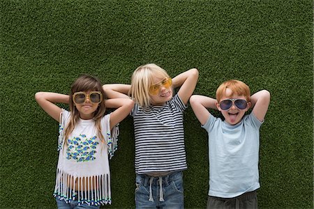 simsearch:400-08831347,k - Children in front of artificial turf wall, hand behind head wearing sunglasses Stock Photo - Premium Royalty-Free, Code: 614-08991137