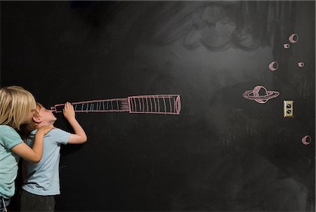 Boys looking through imaginary telescope drawn on blackboard Stock Photo - Premium Royalty-Free, Code: 614-08991166