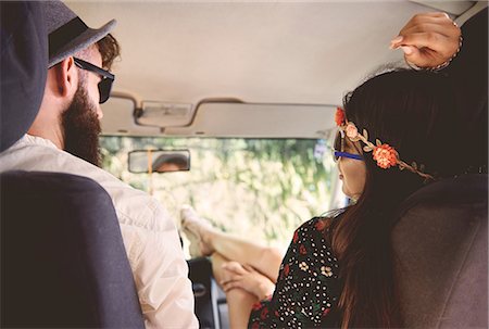 Over shoulder view of young boho couple with feet up in recreational van Stock Photo - Premium Royalty-Free, Code: 614-08991229