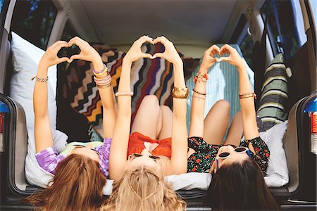 Three young women lying on backs in car boot making heart sign Photographie de stock - Premium Libres de Droits, Code: 614-08991238