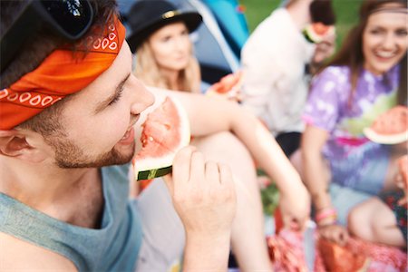 retro women camping - Young boho adult friends eating melon slices at festival Stock Photo - Premium Royalty-Free, Code: 614-08991276